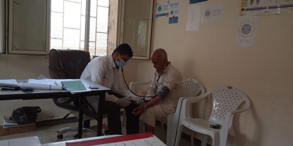 a patient man is getting his BP measured by the doctor after the unit regained functionality